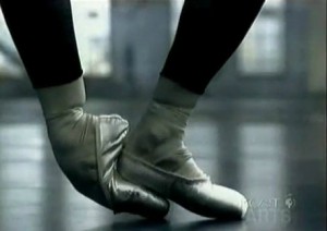 Alesandra Ferri warms up her feet for music video with Sting. Image excerpt from video.